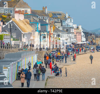 Lyme Regis, Dorset, UK. 13th April 2019. UK Weather: Visitors and families enjoying the school holidays make the best of sunny intervals on a bitterly cold and blustery day at the coastal resort of Lyme Regis as icy easterly winds hit the south coast.  Credit: Celia McMahon/Alamy Live News Stock Photo