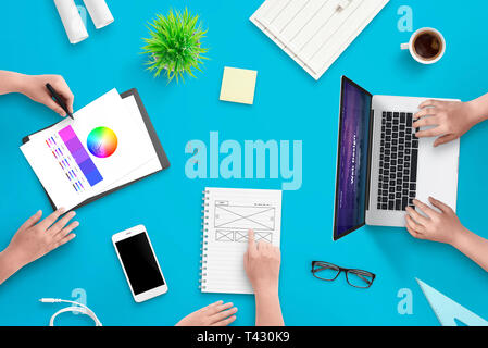 Development team work on user interface web project. Concept of work space. Top view scene. Stock Photo