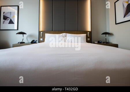Pictures of a generic hotel room - Bed, window, table, lamps all in shot. Stock Photo