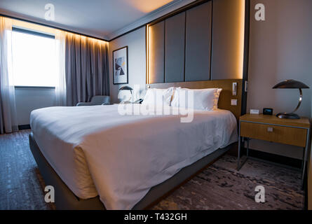 PRAGUE, CZECHIA - 9TH ARPIL 2019: Pictures of a generic hotel room - Bed, window, table, lamps all in shot. Stock Photo