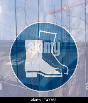 Symbol on a transparent tarpaulin, through which parts of the jobsite are seen, as an indication of safety on a construction site. You can see that yo Stock Photo