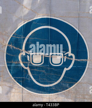 Symbol on a transparent tarpaulin, through which parts of the jobsite are seen, as an indication of safety on a construction site. You can see that yo Stock Photo