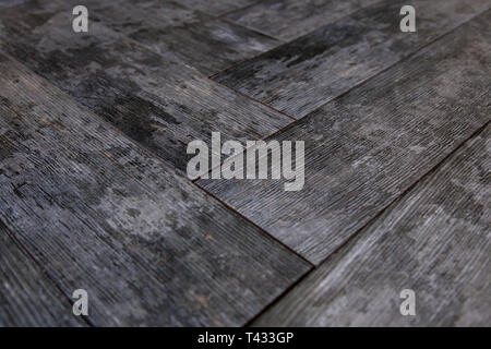 Modern vinyl floor with old wood imitation. Close-up of new gray flooring with texture from tiles with brown grains and knots. Decorative background o Stock Photo