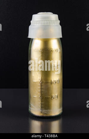 Old soviet glass bottle with measuring scale with bronze powder patina inside Stock Photo