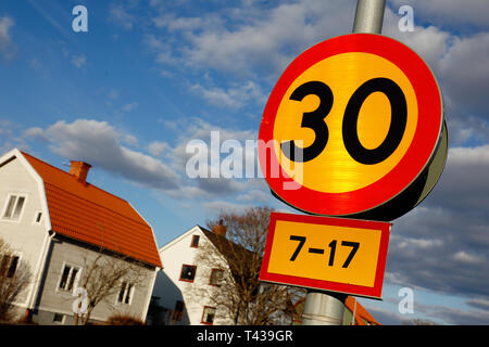 Speed limit 30 road sign located in in urban area with additional panel indicating time during weekdays. Stock Photo