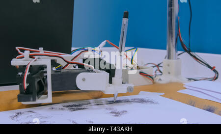 Robotic arm with black pen drawing portrait Stock Photo
