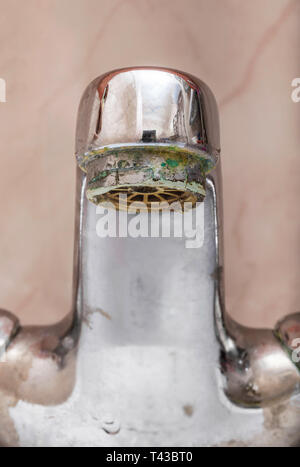 Vertical macro image of closed  tap over a white bathroom sink Stock Photo