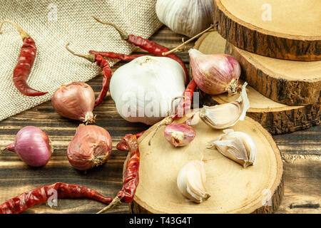 Close up of shallot, garlic, dried red chilli on wooden table background. Stock Photo