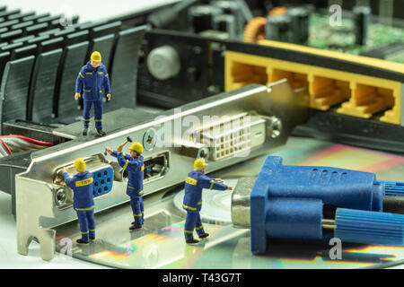 Miniature people maintenance electronic device component. Stock Photo