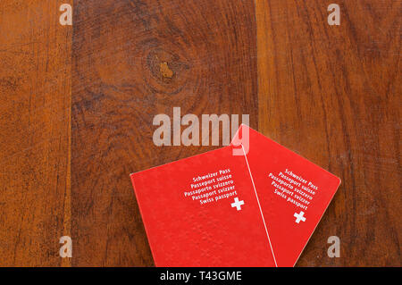 Top view of two Swiss Passports on a wooden table Stock Photo