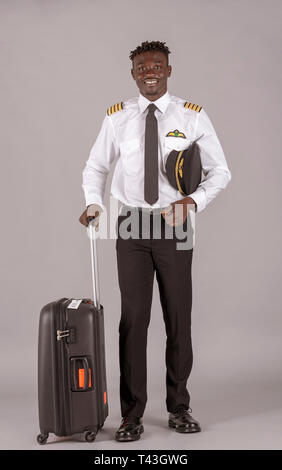 April 2019.  A young airline pilot with an african dred hairstyle and flight bag on wheels. Stock Photo