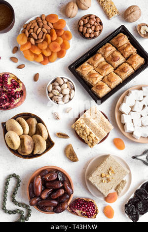 Assortment, set of Eastern, Arabic, Turkish sweets, nuts and dried fruits on white, top view. Holiday Middle Eastern traditional sweet food. Stock Photo