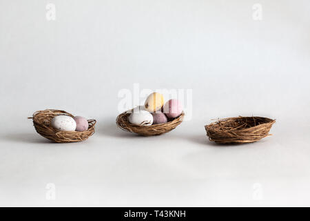 three nests with unequal amounts of chocolate eggs Stock Photo