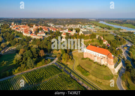 Sandomierz, Poland. Medieval castle in front, old town with town hall tower,  gothic cathedral and Vistula river with bridges in the background. Aeria Stock Photo