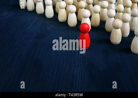 Stand out from the crowd concept. Uniqueness and individuality. Line of figurines. Stock Photo