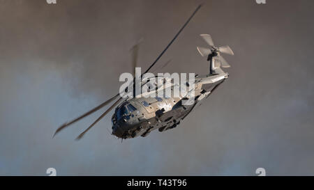 YEOVILTON, UK - 7th July 2018:  Royal Navy   helicopter in flight above pyrotechnic display simulating an attack at Yeovilton  airfield in south weste Stock Photo