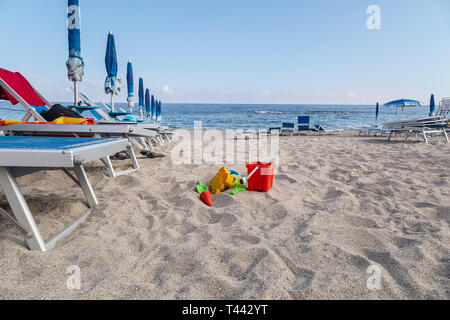 Toys on sand against turquoise sea. Tourism and vacation concept on a tropical beach. Happy sunny day on beach. Stock Photo