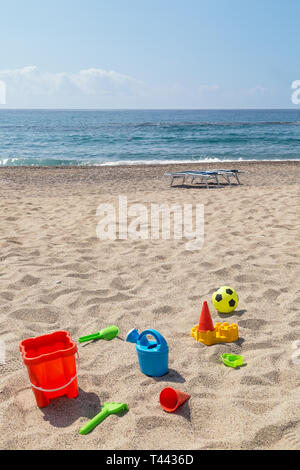 Toys on sand against turquoise sea. Tourism and vacation concept on a tropical beach. Happy sunny day on beach. Stock Photo