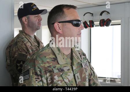 Vessel Master Chief Warrant Officer 3 Terry Lee Senn and Lt. Col. James Collazo stand on the bridge of the U.S. Army’s Logistics Support Vessel Maj. Gen. Charles P. Gross (LSV 5)  as they prepare to dock at Kuwait Naval Base March 13, 2019. Stock Photo