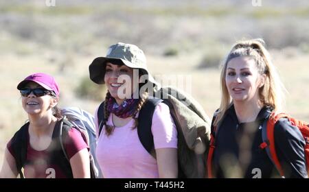 U.S. Army Reserve 1st Lt. Sylvia Orozco, with the 383rd Quartermaster Battalion, and Capt. Roxanna Flores and Sgt. Desiree Lopez with the 356th Transportation Company approach mile marker 8 on the 26 mile Bataan Memorial Death March at White Sands Missile Range, New Mexico, Mar. 17, 2019. The Bataan Memorial Death March is a challenging march through the high desert terrain of the White Sands Missile Range that takes place each spring. The memorial march is conducted in honor of the heroic service members who defended the Philippine Islands during World War II, sacrificing their freedom, healt Stock Photo