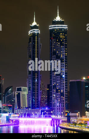 Stunning view of the illuminated Dubai skyline with two magnificent towers and the beautiful colored waterfalls seen from the Dubai Water Canal. Stock Photo