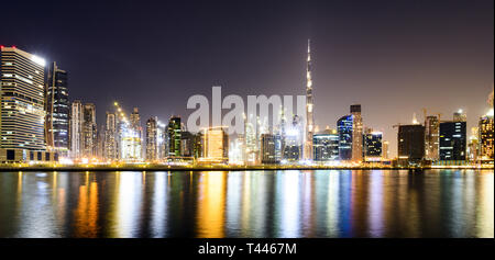 Stunning view of the illuminated Dubai skyline during sunset with the magnificent Burj Khalifa and many other buildings and skyscrapers. Stock Photo