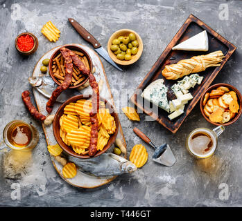 Large selection of snacks for beer. Set of cheeses, fish, chips and snacks Stock Photo