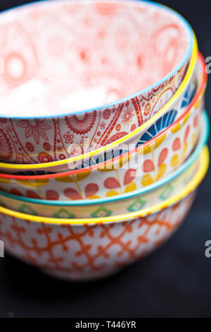Stack of colorful empty ceramic bowls closeup on black board background Stock Photo