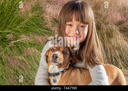 Seven year old girl with her dog in the park Stock Photo