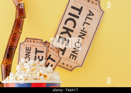 Movie tickets, film strips and popcorn on blue background. Copy space for text. Stock Photo