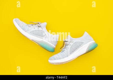 Pair of trendy sport sneakers on yellow background. Top view with copy space. Stock Photo