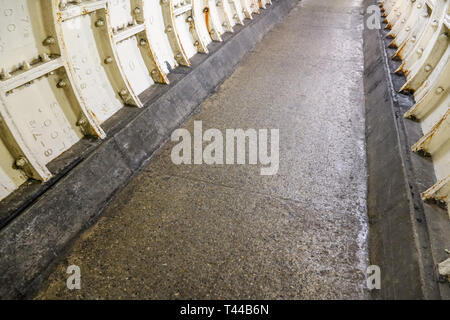 Flat stone floor and heavy iron plating on Thames under water tunnel wall. Stock Photo