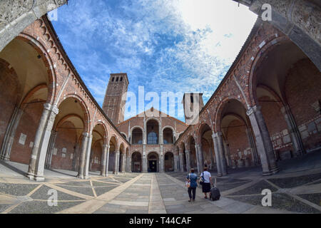 Wide angle view of the Basicilica di Sant Ambrogio, Milan, Italy, with tourists in the foreground Stock Photo