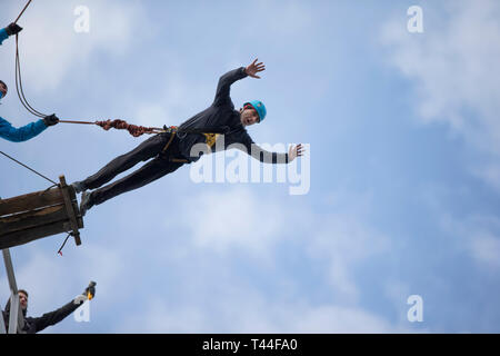 Belarus, Gomel, March 08, 2019. Jumping from the bridge to the rope.Ropejumping.A man jumps from a great height and flies on the rope in the sky. Extr Stock Photo