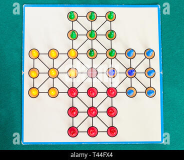 setup of solitaire board game on green baize table. The first mention of the game can be identified in France in 1697 Stock Photo