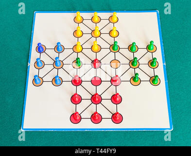 gameplay of solitaire board game on green baize table. The first mention of the game can be identified in France in 1697 Stock Photo