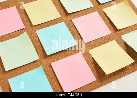 Cork board with pinned colored blank notes Stock Photo