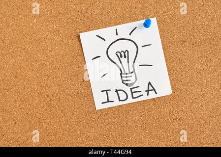 painted light bulb with word idea on cork board Stock Photo