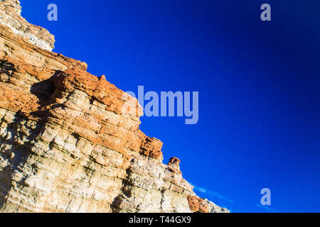 Red and orange geological rock formations in the desert. Stock Photo