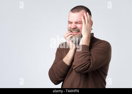 man feeling pain suffering from bad toothache. Stock Photo