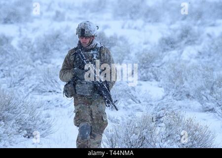 Soldiers from Charlie Company, 2-116th Cavalry Brigade Combat Team, Idaho Army National Guard, practice combined arms battalion, squad level infantry movements on the Orchard Combat Training Center, Jan. 20, 2019. The training combined dry fire rehearsal culminating in a live fire exercise. Stock Photo