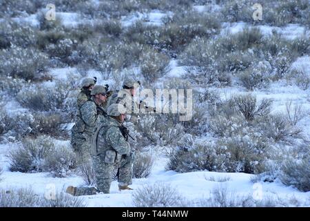 Soldiers from Charlie Company, 2-116th Cavalry Brigade Combat Team, Idaho Army National Guard, practice combined arms battalion, squad level infantry movements on the Orchard Combat Training Center, Jan. 20, 2019. The training combined dry fire rehearsal culminating in a live fire exercise. Stock Photo