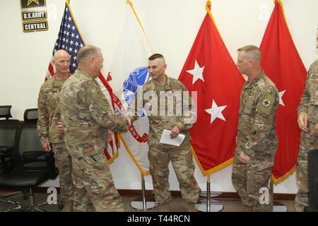 Command Sgt. Maj. Jason Little, Sr. shakes Chief Warrant Officer 4 Brian Morris' hand during a promotion ceremony for Morris at Camp Arifjan, Kuwait, Feb. 21, 2019. Stock Photo