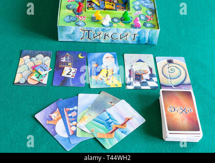 MOSCOW, RUSSIA - APRIL 3, 2019: top view of gameplay in Dixit board game on green baize table. Dixit is a card game created by Jean-Louis Roubira and  Stock Photo