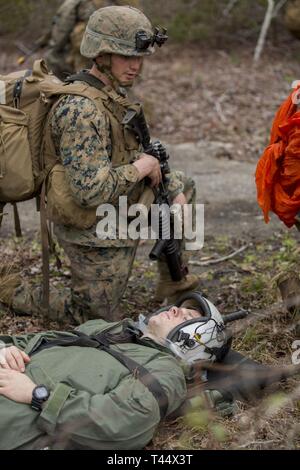 A Marine posts security around a simulated casualty during a Tactical Recovery of Aircraft and Personnel scenario on Camp Lejeune, North Carolina, Feb. 23, 2019. TRAP is a core function of a Marine Expeditionary Unit and the 24th MEU consistently trains to increase TRAP proficiency by rehearsing realistic scenarios which force the Marines and Sailors to quickly make decisions under stress. The Marine is with 1st Battalion, 8th Marine Regiment, 24th MEU. Stock Photo