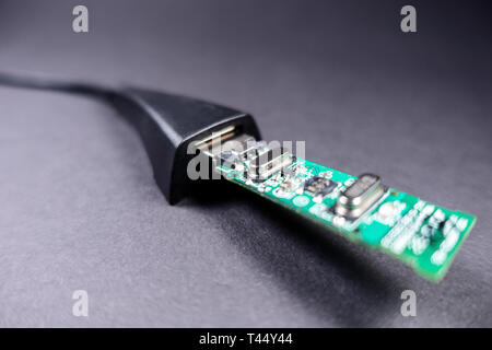 Usb flash drive connector with an electronic card is connected to the connector with a wire. on a black background. macro Stock Photo