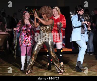Members of the 81st Medical Operations Squadron portray the Austin Powers cast as they make their way down the aisle during the 31st Annual Krewe of Medics Mardi Gras Ball at the Bay Breeze Event Center on Keesler Air Force Base, Mississippi, Feb. 23, 2019. The Krewe of Medics hosts a yearly ball to give Keesler Medical Center personnel a taste of the Gulf Coast and an opportunity to experience a traditional Mardi Gras, which is celebrated by the local communities. The theme for this year's ball was Hollywood vs. Broadway. Stock Photo