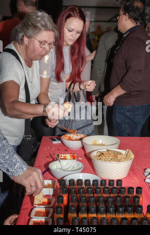 Nootdorp, The Netherlands, April 7, 2019:  People taste different hot sauces made from different types of peppers that are grown in the adjacent green Stock Photo