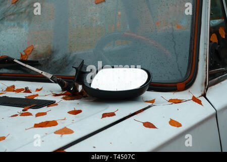 autumn. broken side view mirror is on the hood of an old car. concept Stock Photo