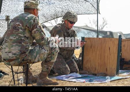 A U.S. Army Soldier assigned to 1st Battalion, 41st Infantry Regiment, 2nd Infantry Brigade Combat Team, 4th Infantry Division, looks down at his compass during the resection and military maps lane, Feb. 26, 2019, at the Expert Infantryman Badge testing site on Fort Carson, Colorado. Infantryman throughout the brigade and other units on the installation are participating in the week long testing to earn the coveted badge. Stock Photo